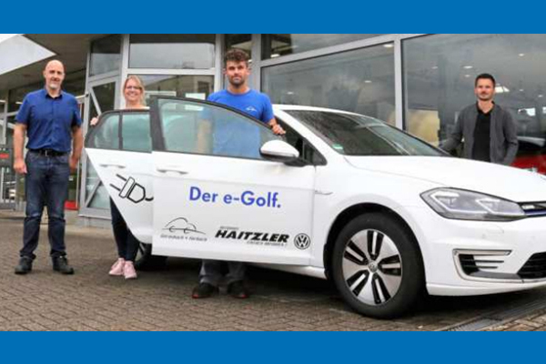 Das Bild zeigt Mitarbeiter und den e-Golf vor dem Autohaus Haitzler