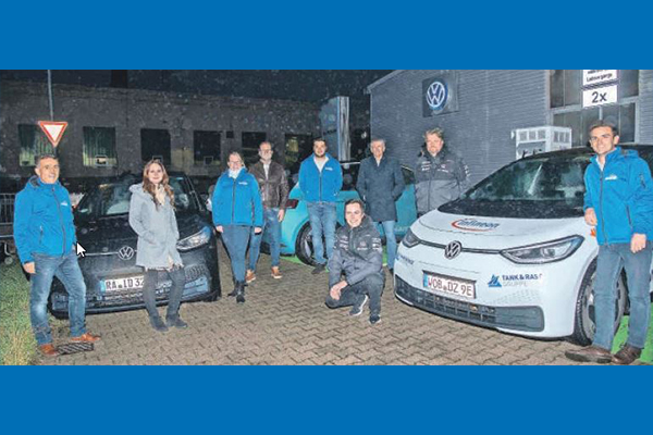 Das Bild zeigt Personen und ein E-Auto vor dem Autohaus Haitzler